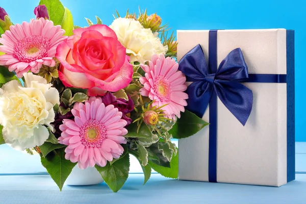 Blue gift box with beautiful bouquet of flowers — Stock Photo, Image