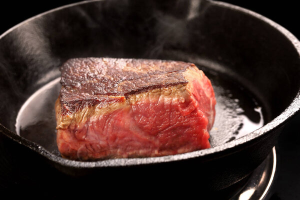 Beef steak on cast iron skillet with empty space for text