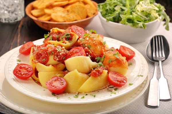 Паста Lumaconi с томатным соусом на деревянном фоне — стоковое фото