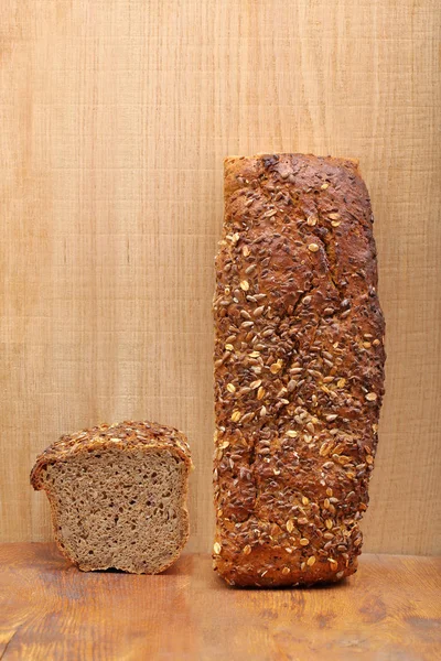 Healthy bread with seeds on wooden background and empty space fo