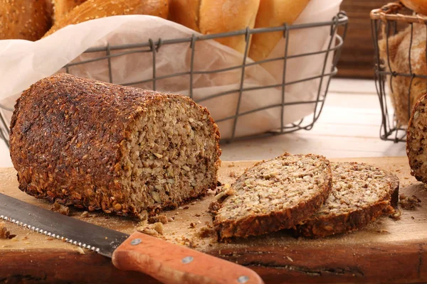 Pão de grão inteiro em uma placa de madeira — Fotografia de Stock