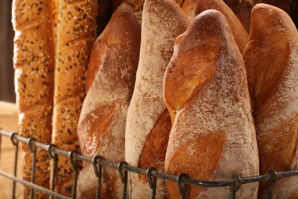 Berbagai jenis baguette dalam keranjang logam di toko roti — Stok Foto