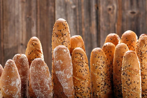 Fresh baguettes in bakery on wooden background — Stock Photo, Image