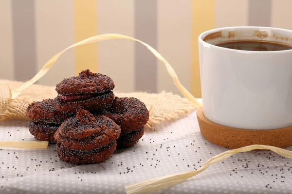 Kopp kaffekopp med vallmo frön cookie på bordet — Stockfoto