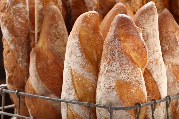 Fresh baguettes in metal basket in bakery — Stock Photo, Image