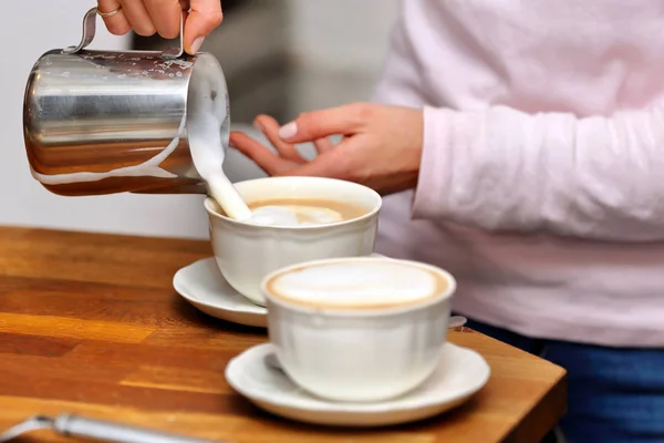 Ung kvinna att göra cappuccino i en bar — Stockfoto