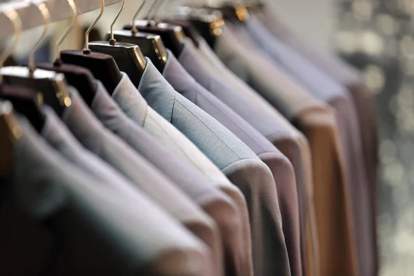 Row of men's suits hanging on hanger — Stock Photo, Image