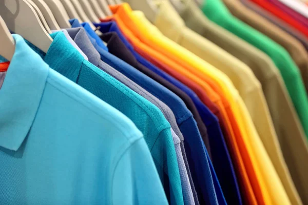 Fila de camisas pólo masculinas em guarda-roupa ou loja — Fotografia de Stock