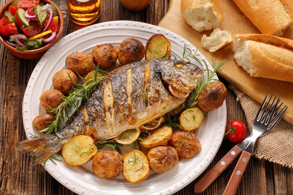 Pesce alla griglia con baguette e verdure sul piatto — Foto Stock