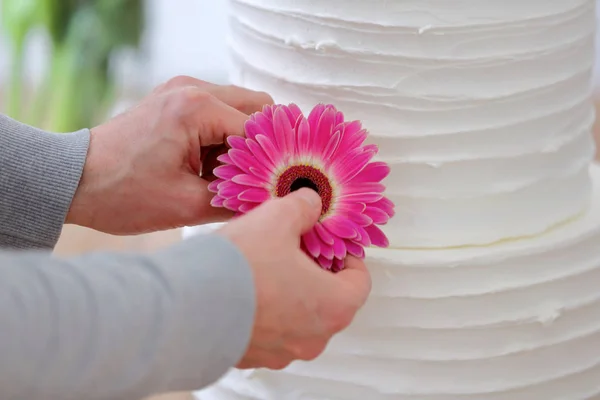 Confeiteiro decora bolo de casamento branco — Fotografia de Stock