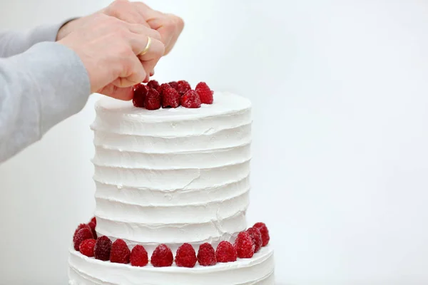 Confeiteiro decora bolo de casamento branco — Fotografia de Stock