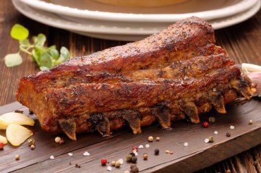 Kızarmış domuz kaburga ahşap arka plan üzerinde otlar ile