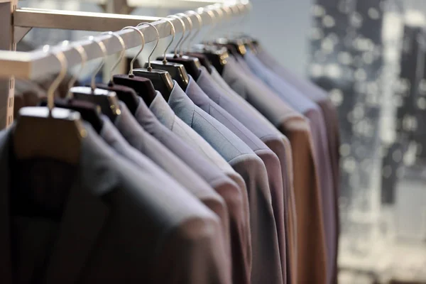 Fila de ternos masculinos pendurados no cabide — Fotografia de Stock