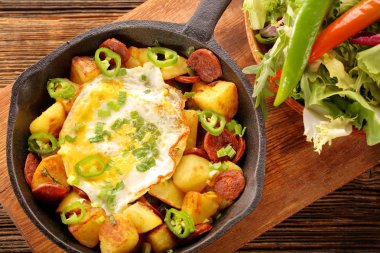 Sosis chorizo ve kızarmış yumurta tava üzerinde fırında patates