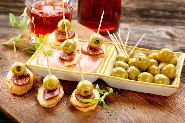 Baked potatoes spanish snack with sausage chorizo and green oliv — Stock Photo, Image