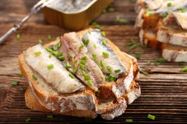 fresh sandwich with sardines on wholegrain bread clipart