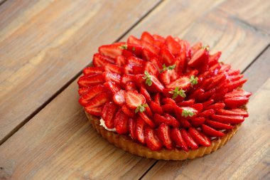 Tahta arka planda taze çilekli turta.