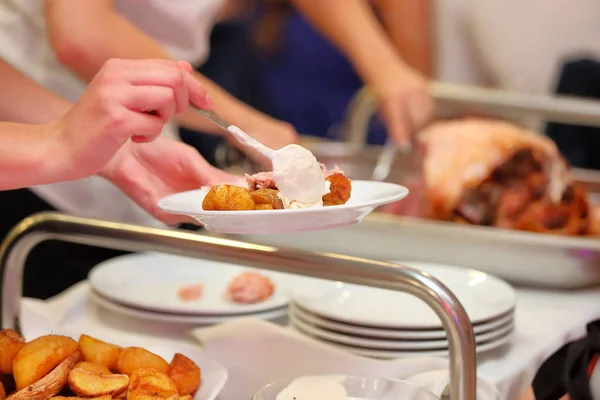 Kelner serwowane są pieczone mięsa i pieczone ziemniaki na imprezie — Zdjęcie stockowe