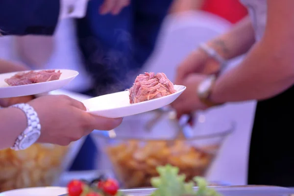Ober serveert geroosterd vlees en gebakken aardappelen op het feest — Stockfoto