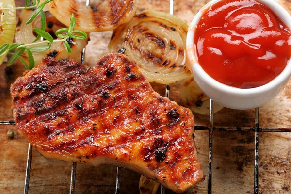 Kızarmış soğan rustik arka plan üzerinde soslu domuz eti ızgara