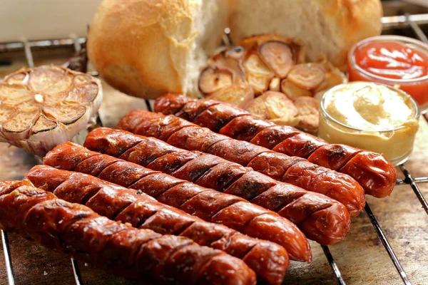 Grilled sausages in oven pan with garlic and onion — Stock Photo, Image