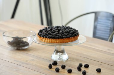 Ahşap arka plan üzerinde taze böğürtlen ile tart