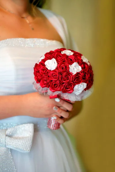 Noiva segurando colorido buquê de flores artificiais com as mãos — Fotografia de Stock