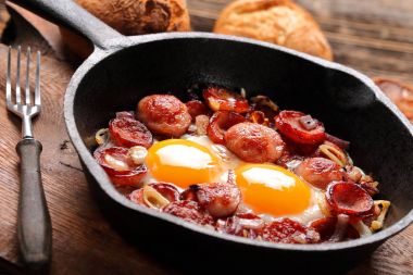 Kızarmış yumurta sosis ve soğan üzerinde tava