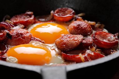 Kızarmış yumurta sosis ve soğan üzerinde tava