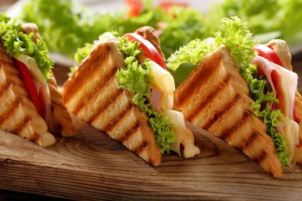 Свежие сэндвичи на деревянном фоне — стоковое фото