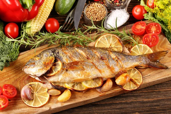 Geroosterde dorada vis met groenten op houten ondergrond — Stockfoto
