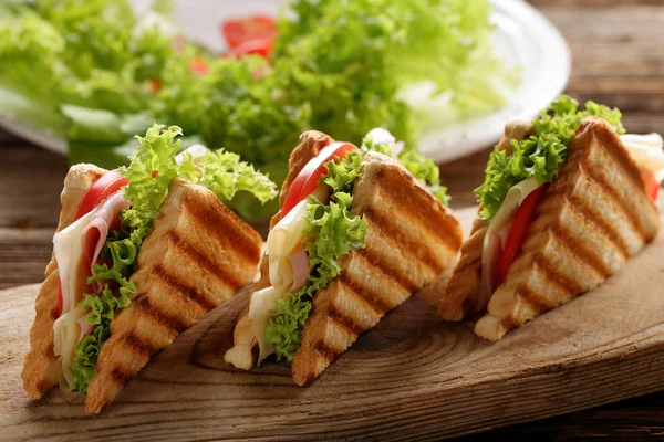Свежие сэндвичи на деревянном фоне — стоковое фото