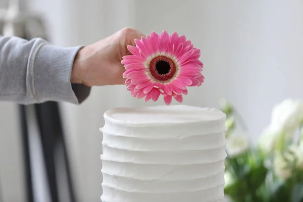 Confeiteiro decora bolo de casamento branco — Fotografia de Stock