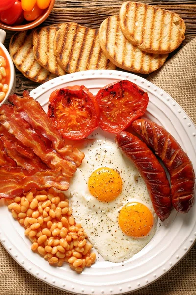 Englisches Frühstück mit Würstchen, gegrillten Tomaten, Ei, Speck, — Stockfoto