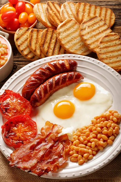 Englisches Frühstück mit Würstchen, gegrillten Tomaten, Ei, Speck, — Stockfoto