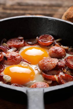 Kızarmış yumurta sosis ve soğan üzerinde tava