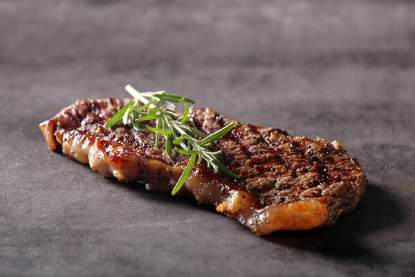 Grilled beef steak on stone board with spice