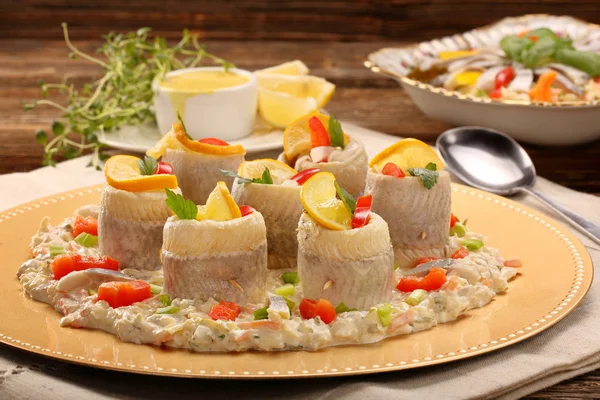 Rolled herrings with fish salad and lemon — Stock Photo, Image