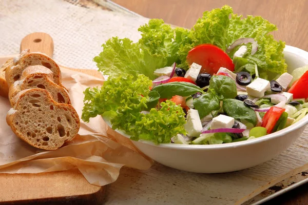 Greek salad with dressing and bread — Stock Photo, Image