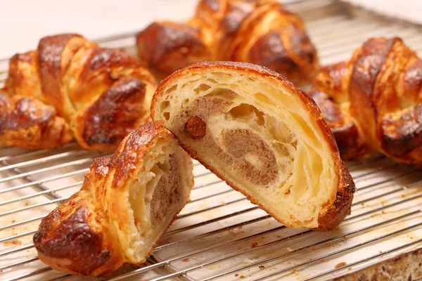 Fresh croissant  with raisins and icing cut in half in the cake — Stock Photo, Image