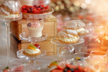 Tatlı kurabiyeler ve tatlılar, etkinlik veya düğün resepsiyonunda çeşitli pastaların yakın plan çekimleri ve mesaj için boş alan