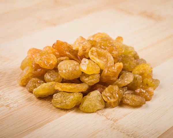 Raisins on wooden cutting board — Stock Photo, Image