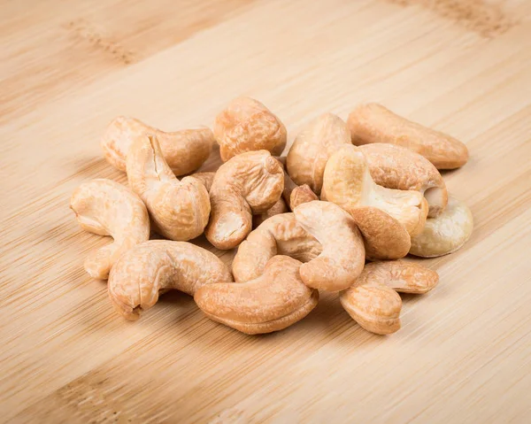 Roasted cashews on wooden cutting board — Stock Photo, Image