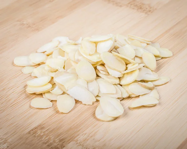 Sliced almonds on wooden cutting board — Stock Photo, Image