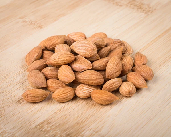 Apricot pits on wooden cutting board — Stock Photo, Image