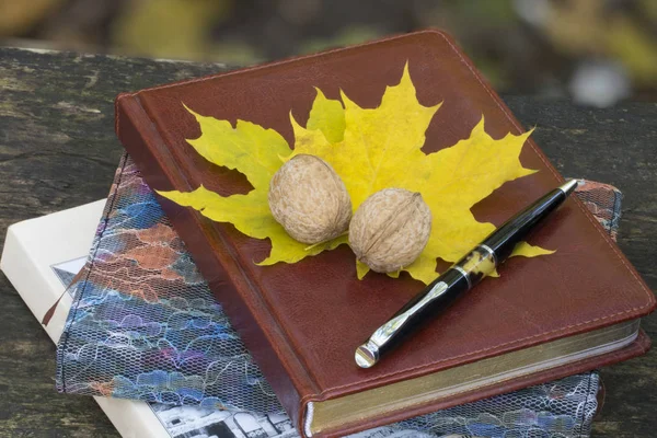 Herfst. Notitieboekje met gele bladeren en walnoot. bovenaanzicht — Stockfoto