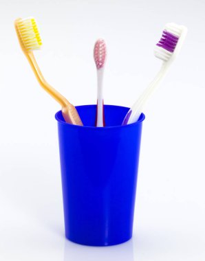 Camdaki diş fırçaları beyaza izole edilmiş. 