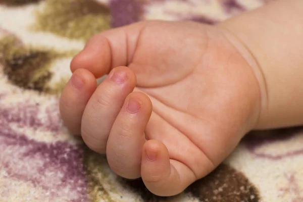 The relaxed hand of a child lying on a blanket — Stock Photo, Image