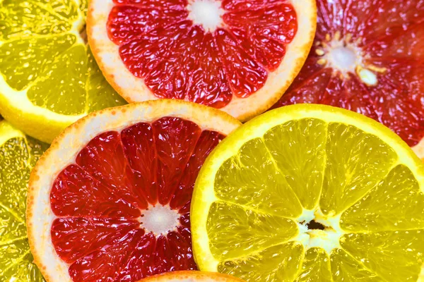 Сочный апельсиновый и грейпфрутовый кольца крупным планом в качестве фона — стоковое фото