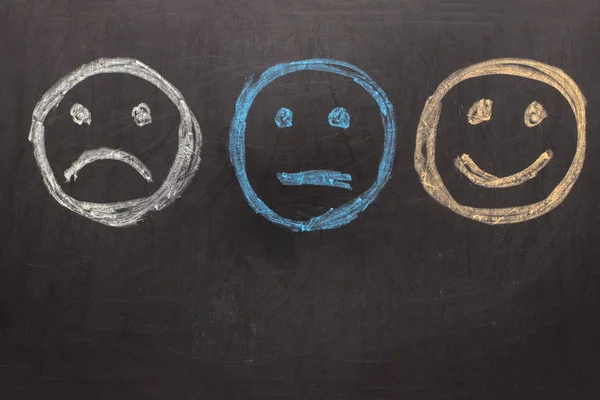 Mutsuz ve mutlu suratlar yazı tahtası üzerinde çizim